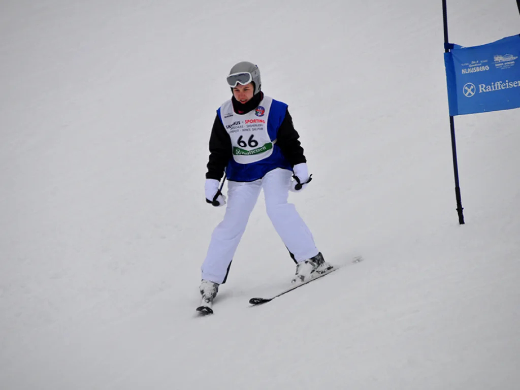 Skifahrerin mit Startnummer 66 in weißer Hose.